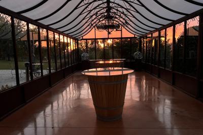 Vue intérieure d'une pièce mansardée lumineuse avec poutres apparentes, sol en bois et une grande fenêtre donnant sur des…