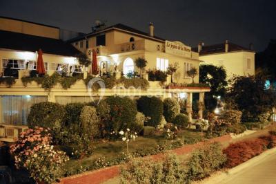 Salle lumineuse avec table ronde dressée pour un repas, nappes blanches et chaises décorées de rubans beiges.