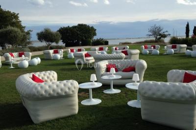 Décor hivernal avec un fauteuil rouge doré entouré de bonhommes de neige, sapins enneigés et guirlandes lumineuses.