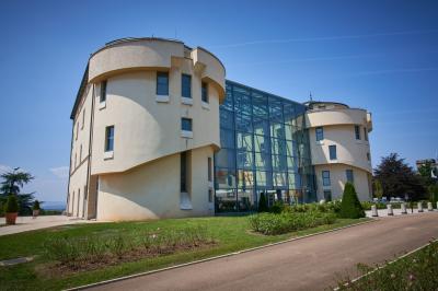 Miniature Location salle Saint-Priest (Rhône) - Château de Saint Priest #9 Façade d'un château historique entouré de pelouses bien entretenues et d'arbres taillés, sous un ciel nuageux.