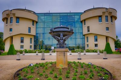 Miniature Location salle Saint-Priest (Rhône) - Château de Saint Priest #1 Façade d'un château historique entouré de pelouses bien entretenues et d'arbres taillés, sous un ciel nuageux.