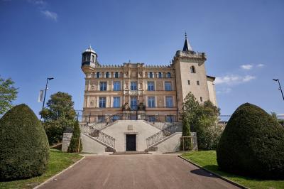 Miniature Location salle Saint-Priest (Rhône) - Château de Saint Priest #7 Façade d'un château historique entouré de pelouses bien entretenues et d'arbres taillés, sous un ciel nuageux.