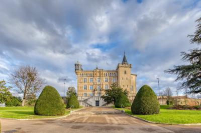 Miniature Le Château de Saint-Priest - Vue du parc Façade d'un château historique entouré de pelouses bien entretenues et d'arbres taillés, sous un ciel nuageux.