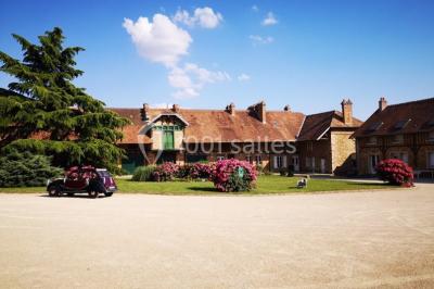 Miniature Location salle Chaumes-en-Brie (Seine-et-Marne) - La Ferme de Forest #2 Un groupe de femmes, dont une en robe blanche, marche sur une pelouse devant un bâtiment en pierre et bois.