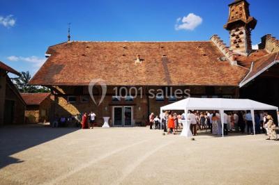 Miniature Location salle Chaumes-en-Brie (Seine-et-Marne) - La Ferme de Forest #8 Un groupe de femmes, dont une en robe blanche, marche sur une pelouse devant un bâtiment en pierre et bois.