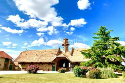 Miniature Location salle Chaumes-en-Brie (Seine-et-Marne) - La Ferme de Forest #1 Un groupe de femmes, dont une en robe blanche, marche sur une pelouse devant un bâtiment en pierre et bois.