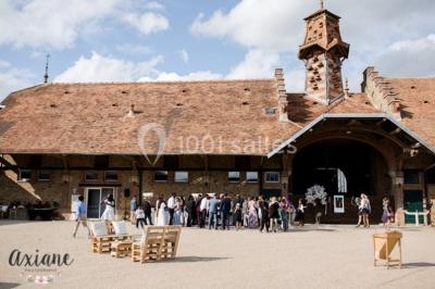 Miniature Location salle Chaumes-en-Brie (Seine-et-Marne) - La Ferme de Forest #11 Un groupe de femmes, dont une en robe blanche, marche sur une pelouse devant un bâtiment en pierre et bois.