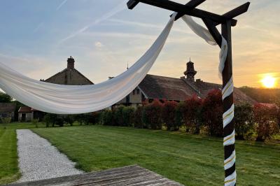 Miniature Location salle Chaumes-en-Brie (Seine-et-Marne) - La Ferme de Forest #12 Un groupe de femmes, dont une en robe blanche, marche sur une pelouse devant un bâtiment en pierre et bois.