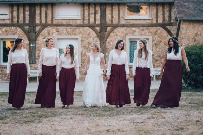 Miniature Location salle Chaumes-en-Brie (Seine-et-Marne) - La Ferme de Forest #33 Un groupe de femmes, dont une en robe blanche, marche sur une pelouse devant un bâtiment en pierre et bois.