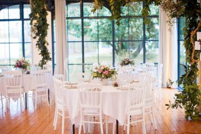 Miniature Location salle Fontains (Seine-et-Marne) - Château de Bourguignon #11 Vue nocturne d'une verrière illuminée par des lumières violettes, entourée d'arbres et d'un jardin.