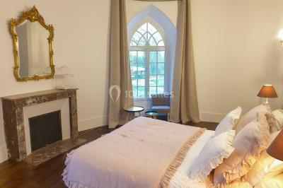 Miniature Location salle Fontains (Seine-et-Marne) - Château de Bourguignon #26 Vue nocturne d'une verrière illuminée par des lumières violettes, entourée d'arbres et d'un jardin.