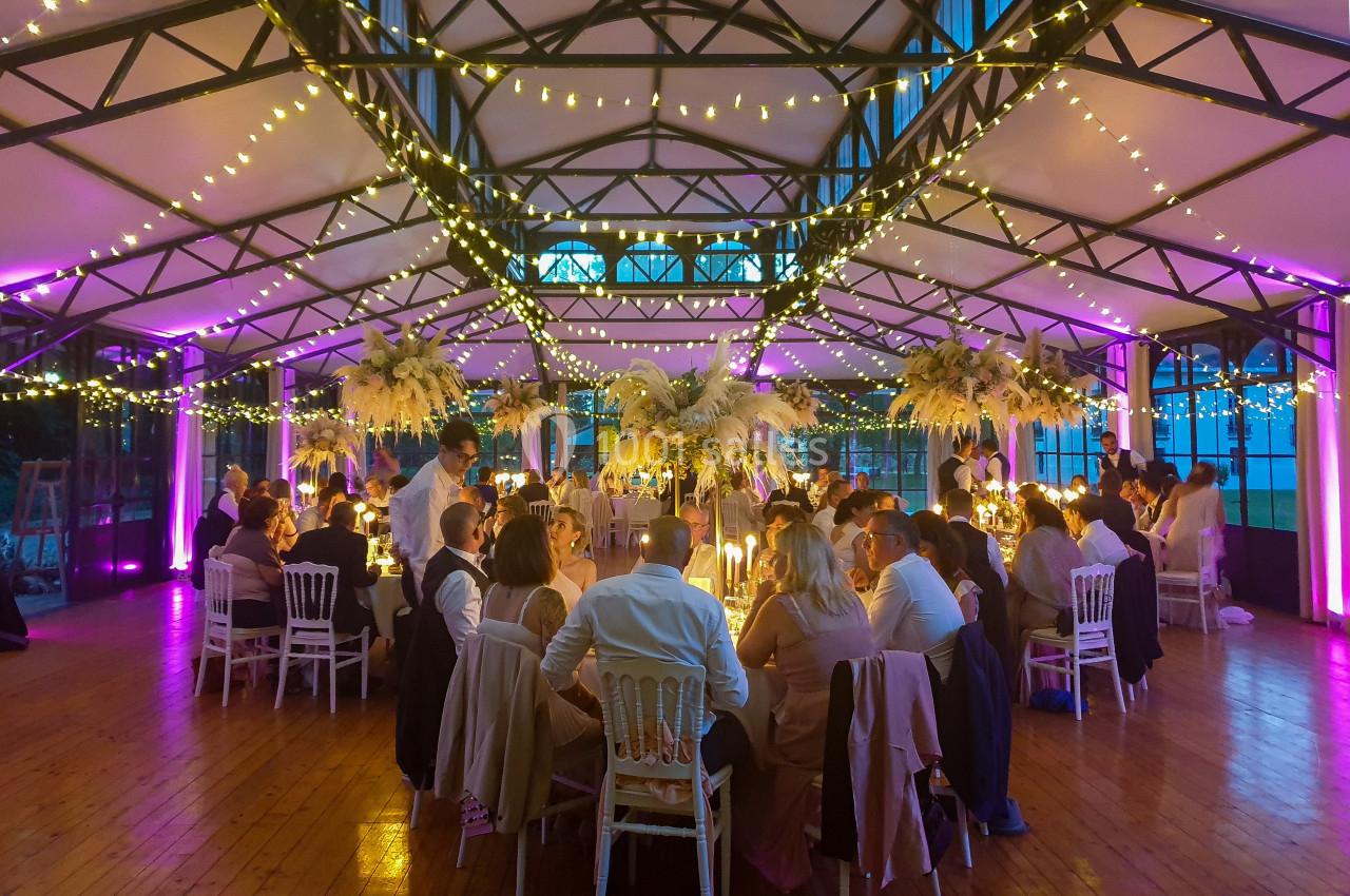 Location salle Fontains (Seine-et-Marne) - Château de Bourguignon #32 Salle de réception décorée avec des guirlandes lumineuses, des tables dressées et des invités assis lors d'un événement.
