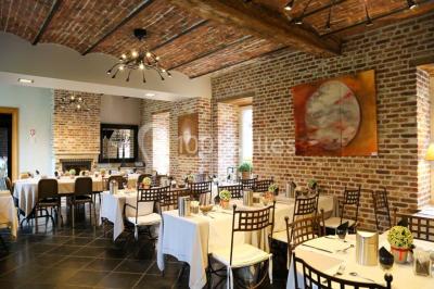 Salle de bain avec baignoire, carrelage blanc et violet, lavabo avec miroir, serviettes pliées et lumière naturelle.