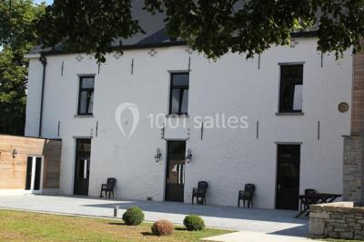 Salle de bain avec baignoire, carrelage blanc et violet, lavabo avec miroir, serviettes pliées et lumière naturelle.