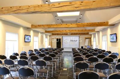 Plafond en bois apparent dans une pièce décorée avec un sapin de Noël blanc, un miroir et des meubles anciens.