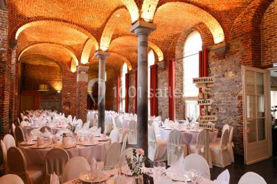 Plafond en bois apparent dans une pièce décorée avec un sapin de Noël blanc, un miroir et des meubles anciens.