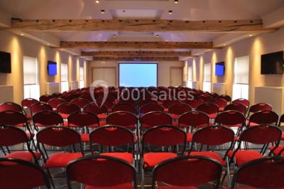 Plafond en bois apparent dans une pièce décorée avec un sapin de Noël blanc, un miroir et des meubles anciens.