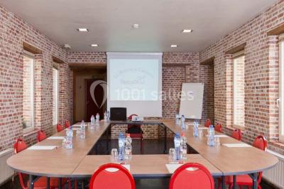 Plafond en bois apparent dans une pièce décorée avec un sapin de Noël blanc, un miroir et des meubles anciens.
