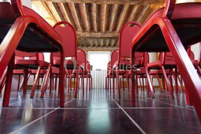 Plafond en bois apparent dans une pièce décorée avec un sapin de Noël blanc, un miroir et des meubles anciens.