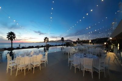 Barques traditionnelles sur une plage bordée de végétation, avec vue sur la mer et des montagnes à l'horizon.