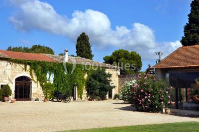 Miniature Location salle Vérargues (Hérault) - Château de Pouget #16 Salle en pierre avec arches, tables décorées et stands alignés, éclairage chaleureux créant une ambiance conviviale.