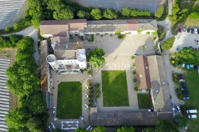 Miniature Location salle Vérargues (Hérault) - Château de Pouget #3 Salle en pierre avec arches, tables décorées et stands alignés, éclairage chaleureux créant une ambiance conviviale.