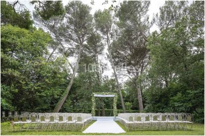 Miniature Location salle Vérargues (Hérault) - Château de Pouget #17 Salle en pierre avec arches, tables décorées et stands alignés, éclairage chaleureux créant une ambiance conviviale.