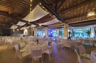 Miniature Location salle Vérargues (Hérault) - Château de Pouget #8 Salle en pierre avec arches, tables décorées et stands alignés, éclairage chaleureux créant une ambiance conviviale.