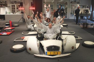 Des personnes debout en cercle dans une grande salle colorée, participant à une activité collective.