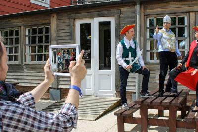 Des personnes debout en cercle dans une grande salle colorée, participant à une activité collective.