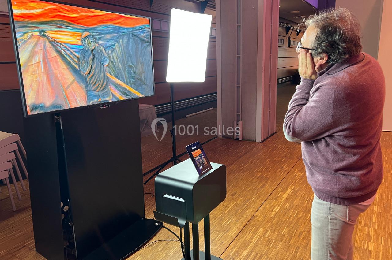 Un homme observe une reproduction numérique du tableau ’Le Cri’ affichée sur un écran dans une salle éclairée.