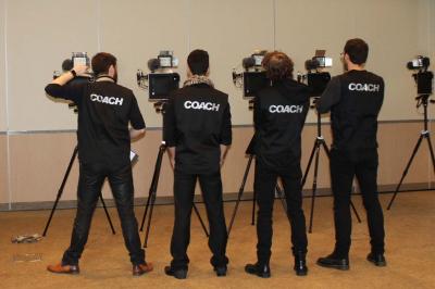 Des personnes debout en cercle dans une grande salle colorée, participant à une activité collective.