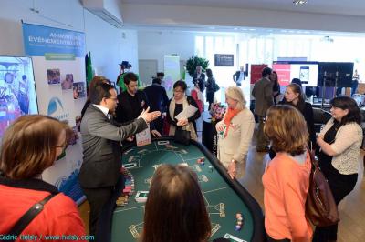 Des personnes debout en cercle dans une grande salle colorée, participant à une activité collective.