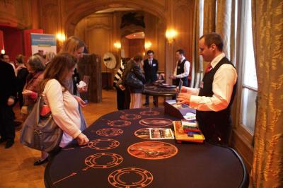 Des personnes debout en cercle dans une grande salle colorée, participant à une activité collective.