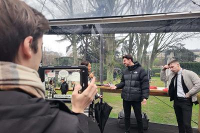 Des personnes debout en cercle dans une grande salle colorée, participant à une activité collective.