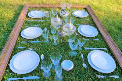 Un tandem décoré de fleurs et d'une caisse en bois, appuyé contre une clôture en bois avec un panneau publicitaire.