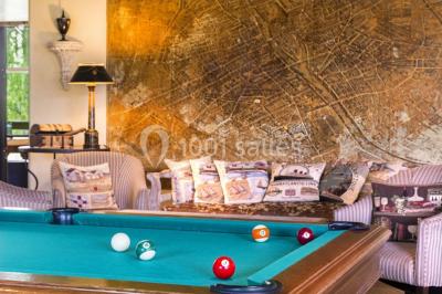 Miniature Location salle Gressy (Seine-et-Marne) - Le Manoir de Gressy #20 Une femme reçoit un massage sur une table dans une pièce chaleureuse avec des rideaux, des bougies et une lumière tamisée.