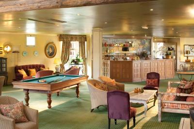 Miniature Location salle Gressy (Seine-et-Marne) - Le Manoir de Gressy #6 Une femme reçoit un massage sur une table dans une pièce chaleureuse avec des rideaux, des bougies et une lumière tamisée.