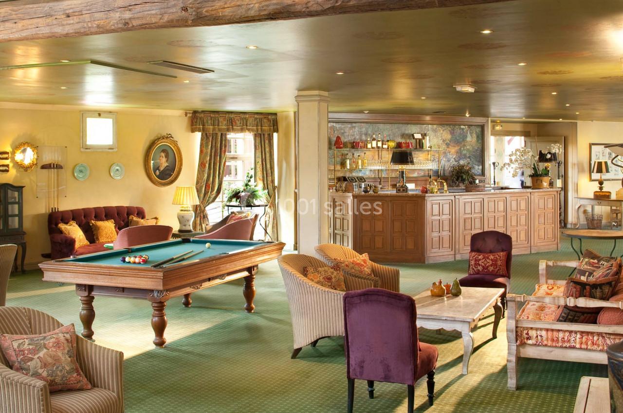 Location salle Gressy (Seine-et-Marne) - Le Manoir de Gressy #6 Salle chaleureuse avec table de billard, fauteuils confortables, bar en bois et décoration élégante.