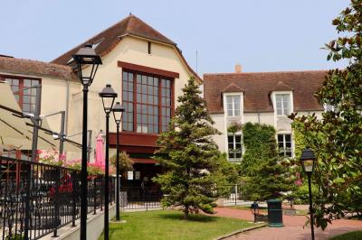 Miniature Location salle Gressy (Seine-et-Marne) - Le Manoir de Gressy #7 Une femme reçoit un massage sur une table dans une pièce chaleureuse avec des rideaux, des bougies et une lumière tamisée.
