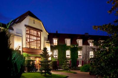 Miniature Location salle Gressy (Seine-et-Marne) - Le Manoir de Gressy #12 Une femme reçoit un massage sur une table dans une pièce chaleureuse avec des rideaux, des bougies et une lumière tamisée.