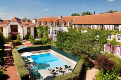 Miniature Location salle Gressy (Seine-et-Marne) - Le Manoir de Gressy #3 Une femme reçoit un massage sur une table dans une pièce chaleureuse avec des rideaux, des bougies et une lumière tamisée.