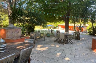 Miniature Location salle Cuers (Var) - Domaine Mas des Palmiers #3 Terrain de pétanque ensoleillé entouré d'arbres et de végétation dans un jardin.