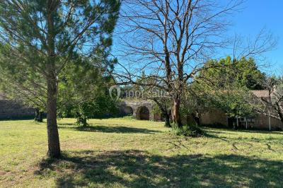Miniature Location salle Cuers (Var) - Domaine Mas des Palmiers #7 Terrain de pétanque ensoleillé entouré d'arbres et de végétation dans un jardin.