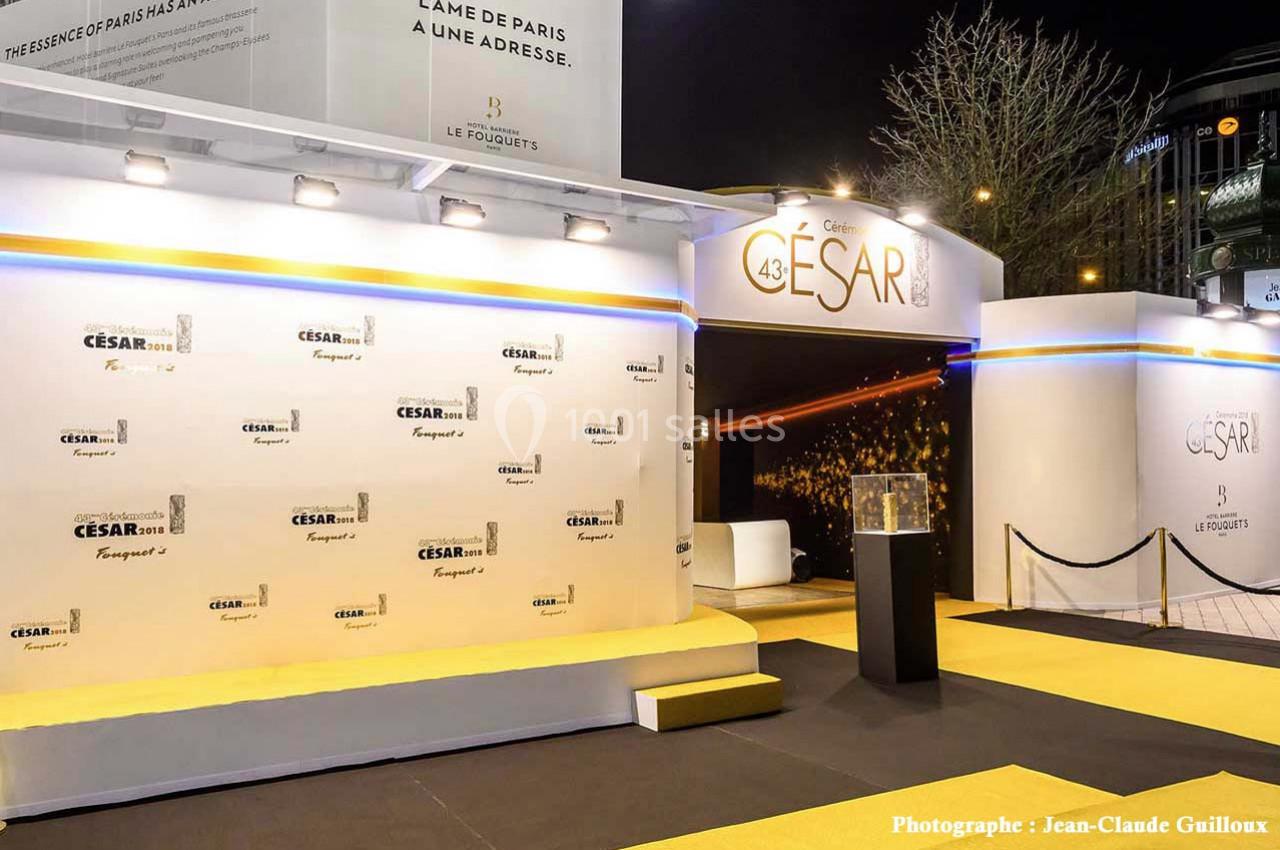 Entrée décorée de la cérémonie des César avec tapis jaune, panneaux de sponsors et éclairage nocturne.