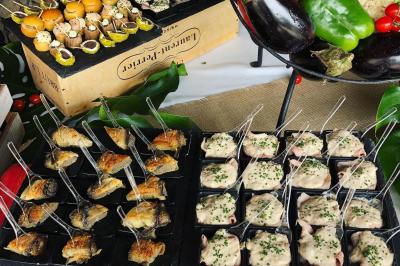 Miniature Traiteur Mouans-Sartoux (Alpes-Maritimes) - Jerome Ravel Traiteur #15 Table en bois décorée de fleurs colorées, verres, assiettes et couverts, installée en extérieur sous une tente.