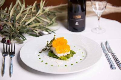 Personne utilisant une trancheuse rouge pour couper de la charcuterie dans un environnement professionnel.