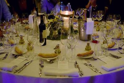 Personne utilisant une trancheuse rouge pour couper de la charcuterie dans un environnement professionnel.