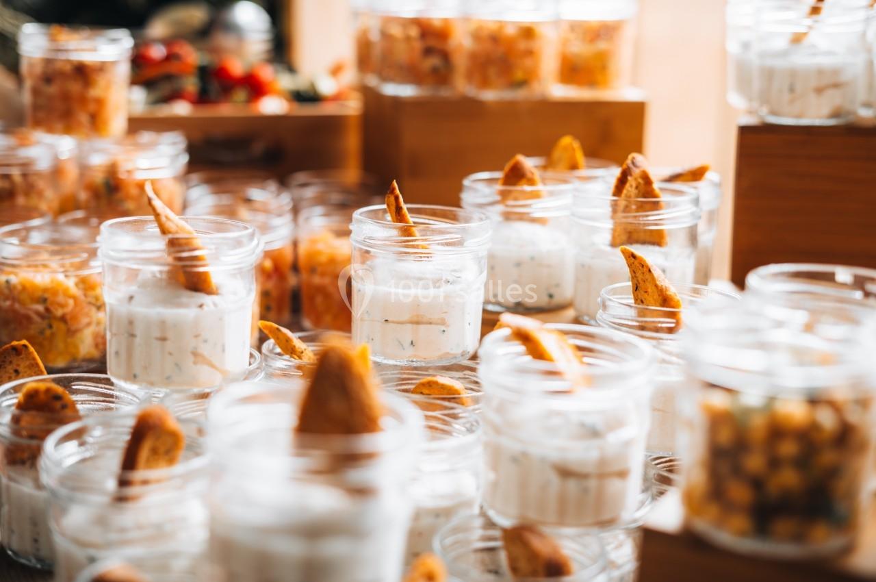 Verrines de crème blanche garnies de morceaux de pain croustillant, disposées sur une table en bois.