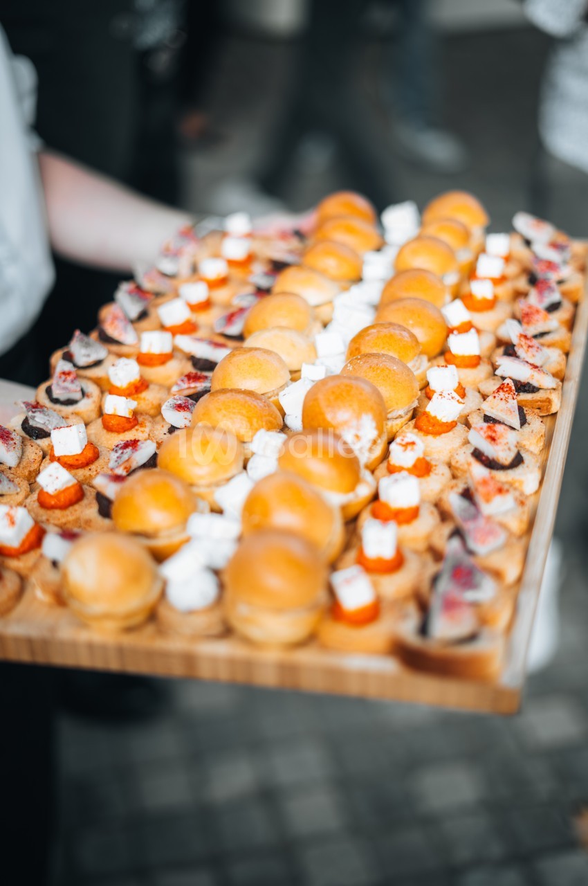 Plateau de bouchées apéritives variées comprenant des mini-burgers, des toasts garnis et des amuse-bouches.